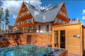 una casa con una piscina di fronte di Apart Vip Zakopane a Zakopane