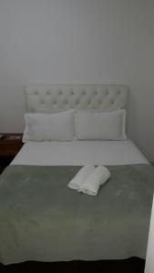 a large white bed with a white headboard and pillows at Pousada do Pascoal in Juquei