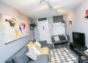 a living room with a couch and a tv at Malone Place Apartment in Belfast