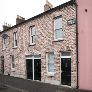 a red brick building with black doors and windows at Malone Place Apartment in Belfast