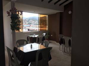 ein Restaurant mit Tischen und Stühlen und einem großen Fenster in der Unterkunft Hotel Marialu in Ocaña