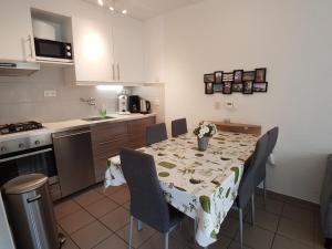 a kitchen with a dining room table with chairs and a tablecloth at ZAND Bed by the Sea in Westkapelle