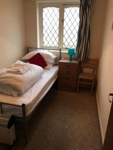 1 dormitorio con cama, ventana y silla en Flat 9a Badby Close, en Mánchester