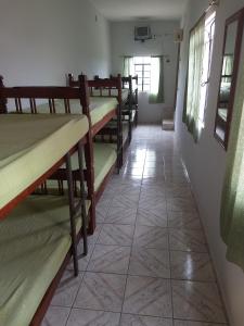 a row of bunk beds in a room with a tile floor at Pousada Primavera in Cachoeira Paulista