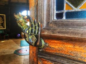 a wooden door with a iron hand on it at Octogono Om Shanti in Villa Serrana