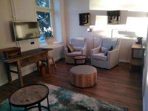 オイティンにある4 Sterne Wohnen "Zum alten Forsthof" am Schlosspark, App 1 "smuck und groot"のリビングルーム(椅子、テレビ、テーブル付)