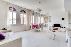 a white living room with a table and chairs at Residence La Fontaine in Venice-Lido