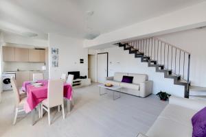a white living room with a table and a couch at Residence La Fontaine in Venice-Lido