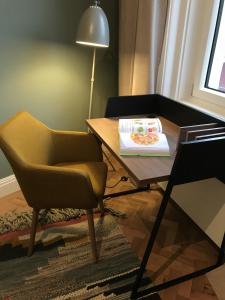 einen Tisch mit einem Stuhl und ein Buch darauf in der Unterkunft My Home in Vienna - Smart Apartments - Margareten in Wien