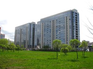 a tall building in a field with trees in front at Студия у метро Московская in Saint Petersburg