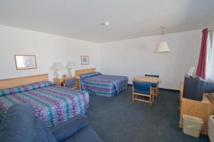 米蘇拉的住宿－布魯克斯聖汽車旅館，酒店客房配有床、沙发和桌子。