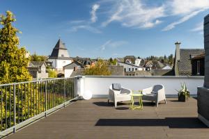 um pátio com 2 cadeiras e uma mesa na varanda em SOON appartements em Simmern