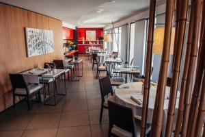 a dining room with tables and chairs in a restaurant at Red's Redaelli Hotel in Barzanò