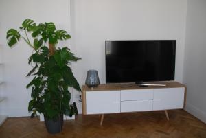 einen Flachbild-TV auf einem weißen Schrank neben einer Anlage in der Unterkunft My Home in Vienna - Smart Apartments - Margareten in Wien
