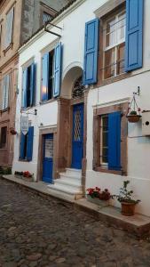 um edifício com portas azuis e escadas numa rua em Cunda Adali Pansiyon em Ayvalik