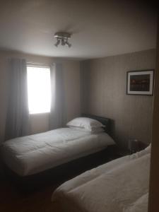 a bedroom with two beds and a window at Liverpool Apartments in Liverpool
