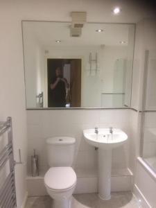 a bathroom with a toilet and a sink and a mirror at Liverpool Apartments in Liverpool