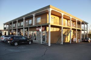 un edificio con un coche aparcado en un aparcamiento en Hotel Motel Le Château, en Lac-Mégantic