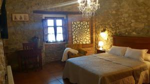 a bedroom with a bed and a window and a chandelier at El Juacu in Llanes