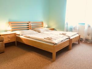 a bed with a wooden headboard in a bedroom at Rusovský Penzión in Bratislava