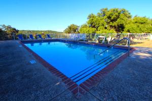 a swimming pool with blue water and a fence at The Shores at Lake Travis in Lago Vista