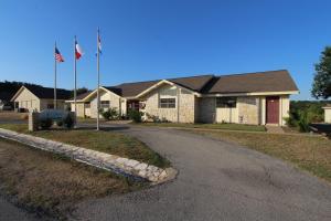 uma casa com duas bandeiras em frente a uma entrada em The Shores at Lake Travis, a VRI resort em Lago Vista