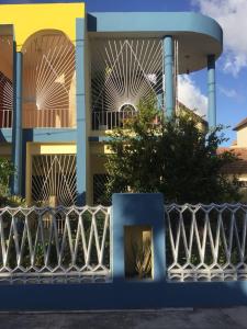 a building with a fence in front of it at Nicole's Guest Home in Higuey