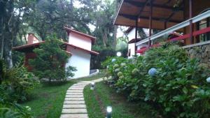 een tuin met een stenen pad naast een huis bij Recanto dos Kerr in Monte Verde