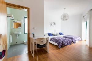 1 Schlafzimmer mit 2 Betten, einem Schreibtisch und einem Spiegel in der Unterkunft H18 in Horta