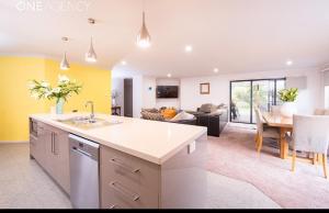 a kitchen and living room with a sink and a table at Euphoria House in Wynyard