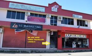 un edificio rojo y blanco con señales en él en Times Traveller Lodge 2 en Kota Belud