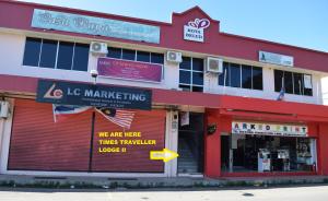 a red and white building with signs on it at Times Traveller Lodge 2 in Kota Belud