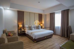 a hotel room with a large bed and a couch at Orchardz Hotel Bandara in Tangerang +26 photos