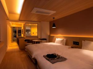 a hotel room with two beds and a table at UAN kanazawa in Kanazawa