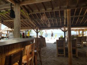 un bar sulla spiaggia con persone che camminano sulla spiaggia di Puri Air Beach Resort & Spa a Gili Air
