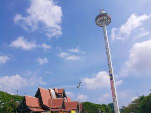 a tv tower with a building in front of it at branded hotel in Malacca