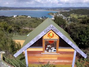 a doghouse with a window on top of a hill at Ocean Purring Views in Tutukaka