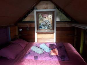 a purple bed in a room with a window at Ocean Purring Views in Tutukaka