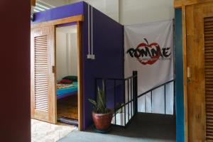a door to a room with an apple sign on it at Pomme Hostel Restaurant & Bar - Private Sleeping Cabins in Battambang