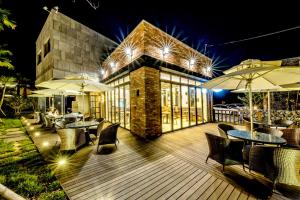 a deck with tables and umbrellas at night at Arts Spa&Poolvilla in Jeju