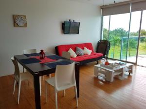 sala de estar con mesa y sofá rojo en Apartment Bala Beach, en María Chiquita