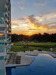 een uitzicht op de zonsondergang vanuit een gebouw met een zwembad bij Apartment Bala Beach in María Chiquita