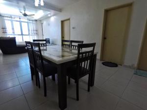 a dining room with a table and chairs in a room at Sultan Bridge Place in Kota Bharu