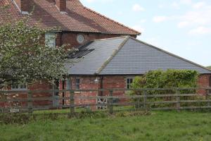 una casa di mattoni con una recinzione di fronte di The Annex at Oliver Farm a York