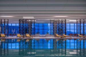 una habitación con sillas y una piscina de agua en Hyatt Regency Shanghai Wujiaochang en Shanghái