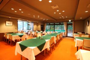 une salle à manger avec des tables et des chaises vertes dans l'établissement Le Vert Zao, à Zao Onsen