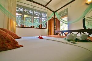 Un pat sau paturi într-o cameră la Sagarika Beach Hotel