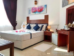 a bedroom with a bed with pink flowers on it at Ceylon Pearlwing Resort in Negombo +108 photos