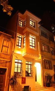 イスタンブールにあるヴィラ ペラ スイート ホテルの夜間の照明付き窓のある高層ビル