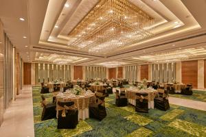 a banquet hall with tables set up for a banquet at Hotel Royal Orchid Bangalore in Bangalore